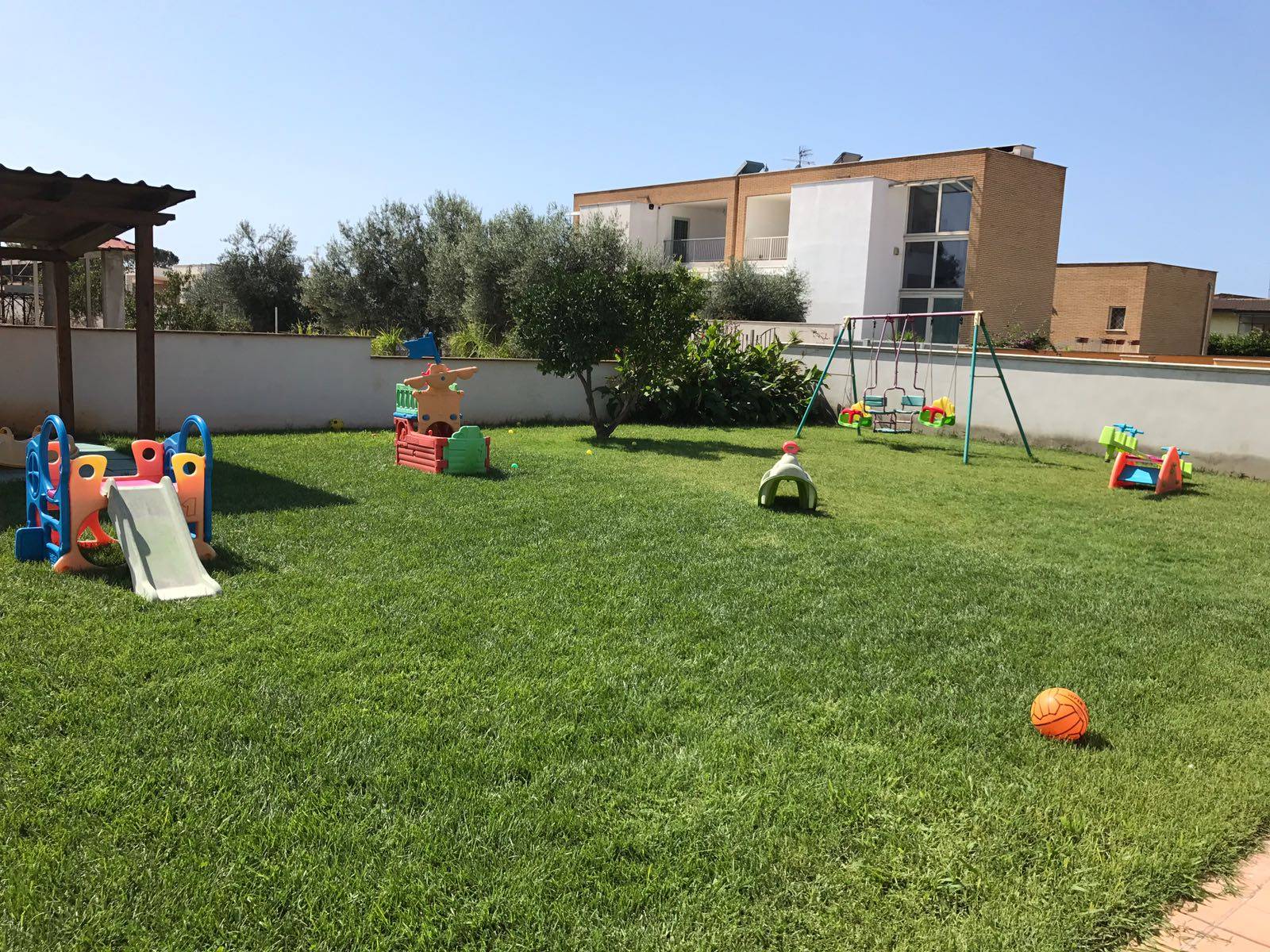 Il giardino del nido con scivolo e area gioco