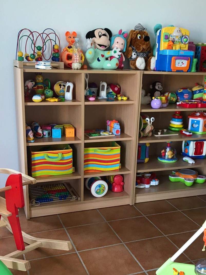 Scaffali aperti con materiali e giochi ordinati